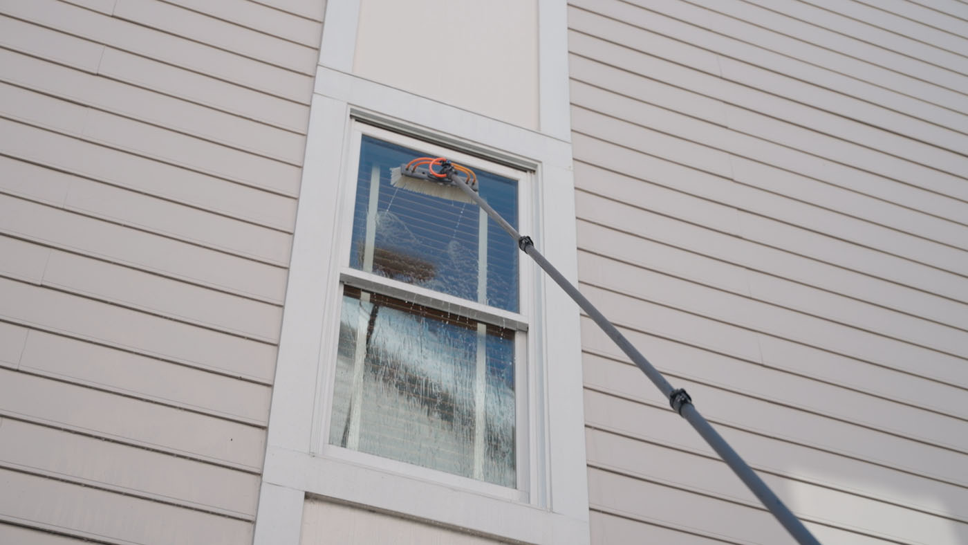 A second story window being cleaning by a Window Ninjas team member. 